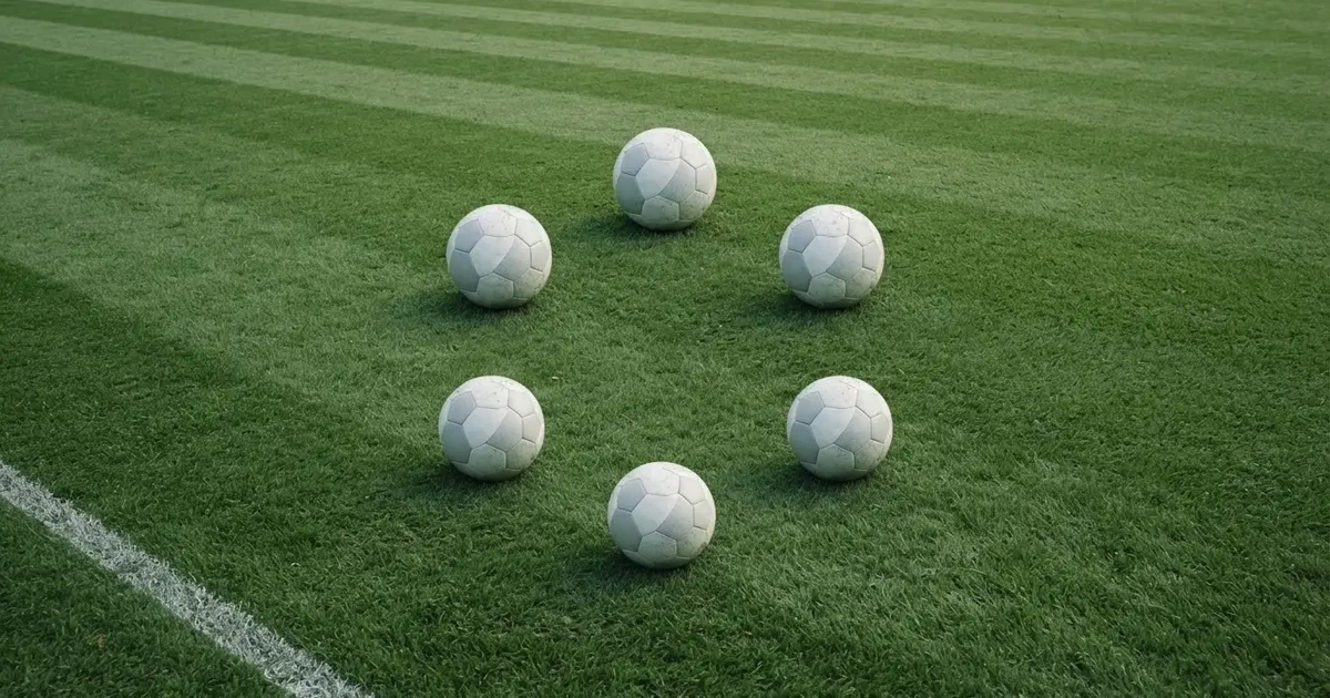 Sechs Fußbälle in einem Kreis auf einem gepflegten Rasen, von oben aufgenommen, gleichmäßiges Tageslicht.